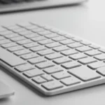 Magic Keyboard com Touch ID: Vale a Pena para Mac no Brasil? Magic Keyboard com Touch ID em uma mesa moderna com um MacBook, destacando o sensor biométrico.