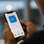 Pessoa concentrada usando o Modo Foco do iOS 18 em seu iPhone para evitar distrações e aumentar a produtividade.