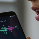 iPhone com a Siri ativa, mostrando o ícone de voz e a pessoa falando, sem tocar no aparelho, em um ambiente moderno.
